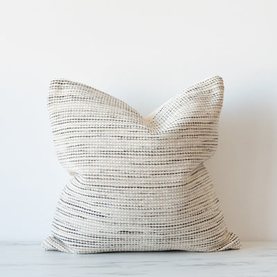 Neutral square pillow with cool tones of hand woven textiles