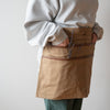 Tan utility apron worn by model